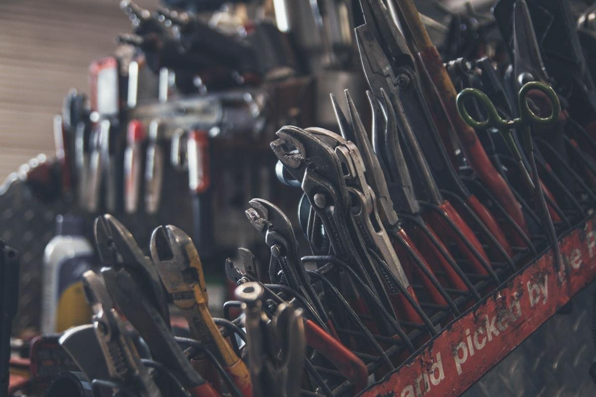 Close-up of a locksmith's precision hand tools including pliers and pick tools used for non-destructive lock entry.